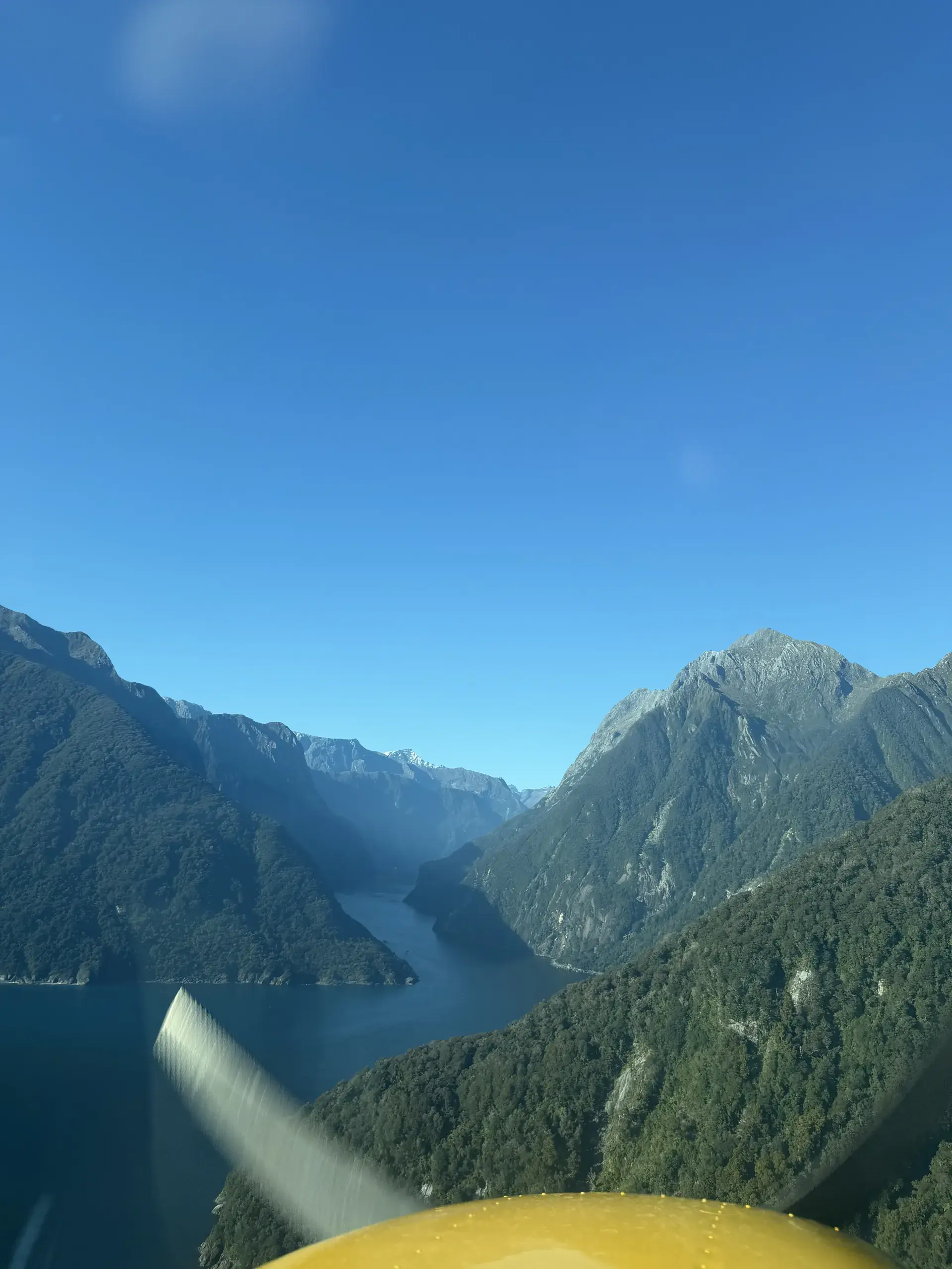 Flying into Milford Sound between fiord walls