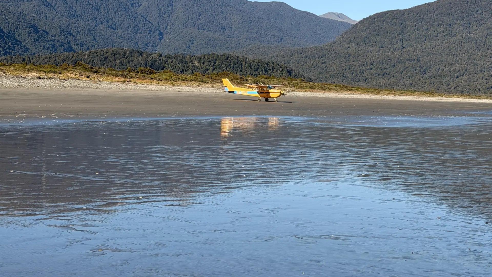 Flyinn Cessna 172 parked on the beach at Big Bay, West Coast, New Zealand